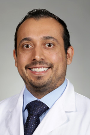 Portrait of medical student Richard Granados in white coat and smiling