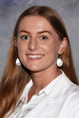 Portrait of medical student Hannah Posey in white coat and smiling