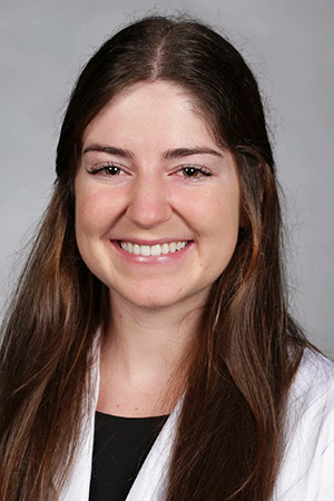Portrait of medical student Jennifer Tashjian in white coat and smiling