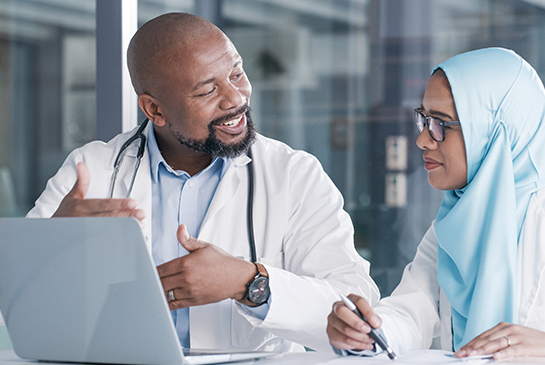 image of man and women talking by a laptop