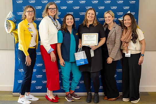 Group of nurses receiving an award, taking a photo.