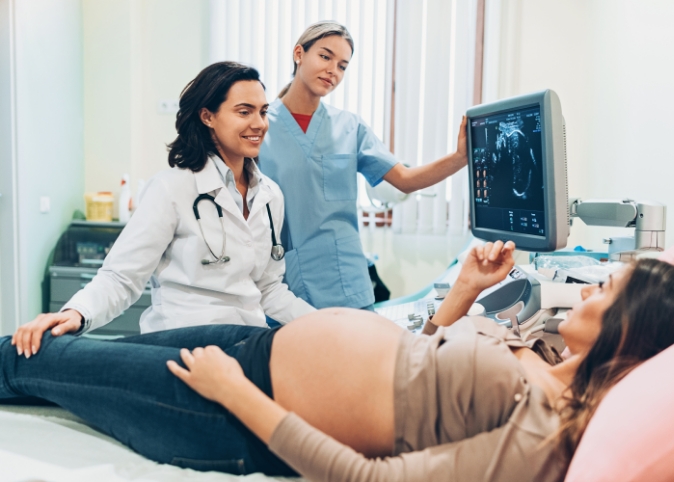 doctor and nurse talking with pregnant patient