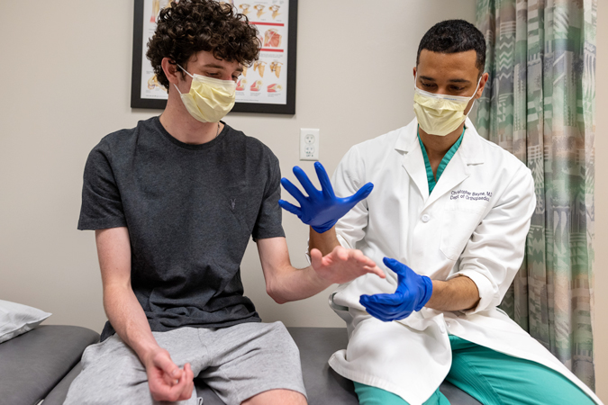 Dr. Bayne examining a patient's arm