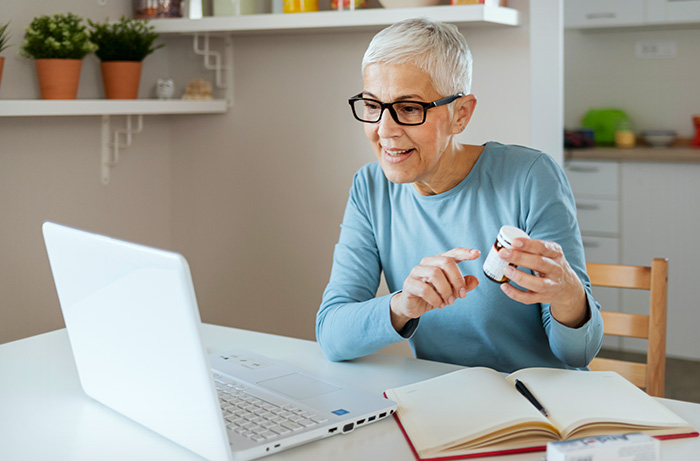 Elderly woman using laptop to schedule health care appointment