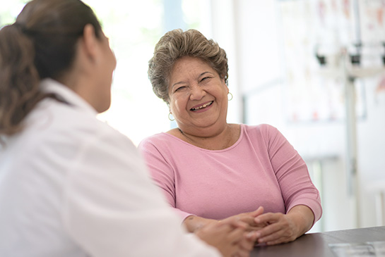 Adult female patient talking with doctor in clinical office