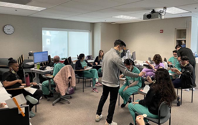 Eleven residents prepare for clinic and coursework in large study room.