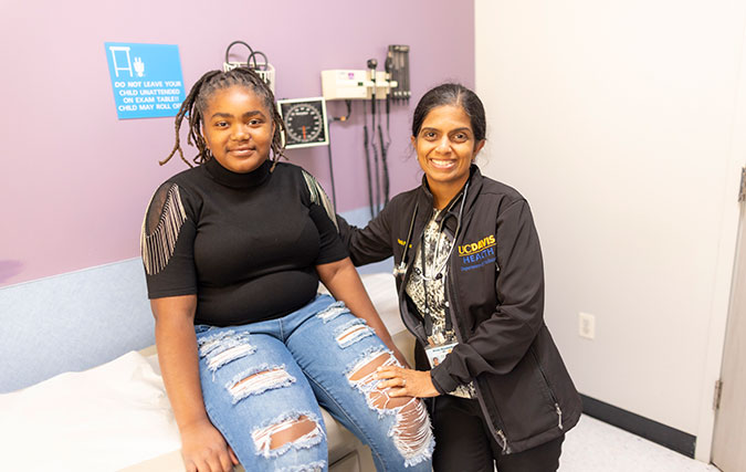 Dr. Nandalike with female patient in clinic room smiling