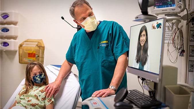 Dr. Marcin with patient, using telemedicine with another doctor