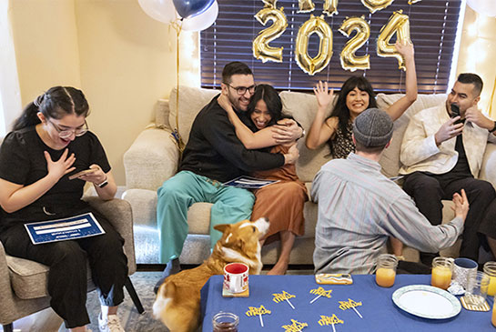 Family match day photo, family celebrates on couch with ballons.