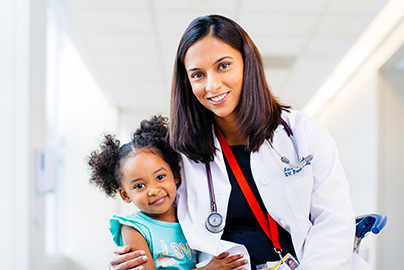 Doctor holding young girl patient.