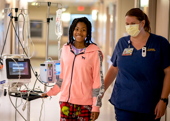 Sickle cell patient with nurse in hospital hallway