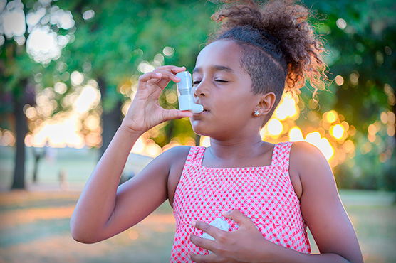 Young child with an inhaler outdoors
