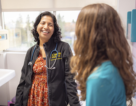 Ulfat Shaikh with a patient in clinic
