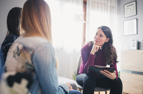 Two young women sitting in a therapy session