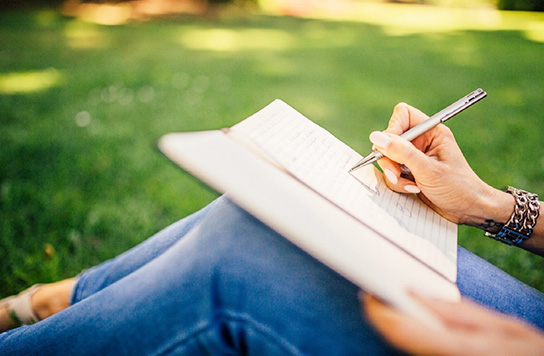 A young woman writing in a notebook