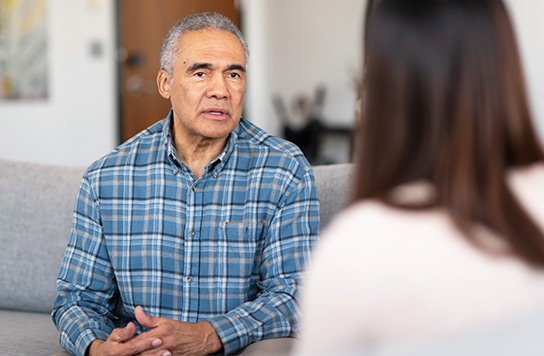 older man talking with a female provider in an office setting
