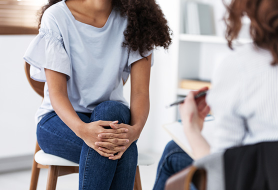 Young female patient sitting with provider in clinic setting