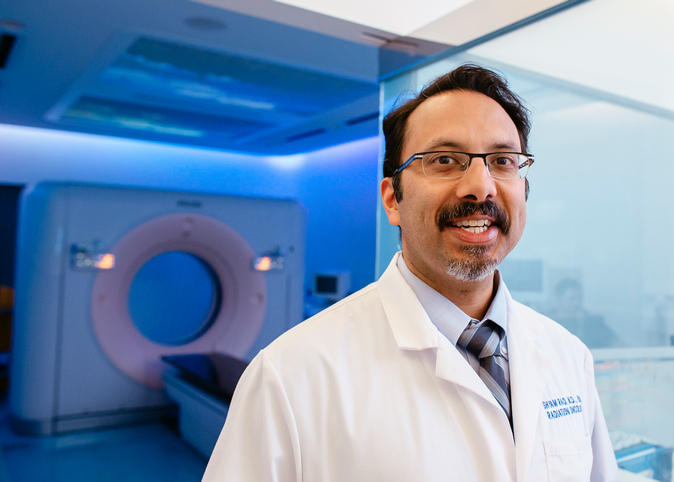 Radiation oncologist Shyam Rao standing in front of treatment room