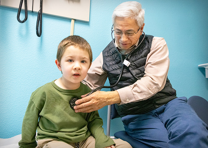 Pediatric cardiology Frank Ing listening with stethoscope with young patient