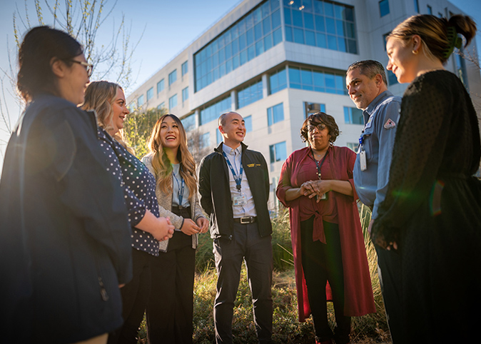 Seven UC Davis health staff members gathered outside in a courtyard.