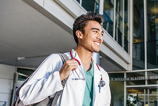 Student in front of UC Davis School of Medicine 
