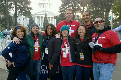 A group of UC Davis Medical students posing in front of the California Capitol building at Christmas time.