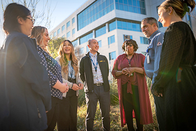 A group of employees standing in a courtyard talking.