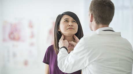 Doctor examining a woman’s neck