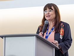 Image shows Kim Barrett, Vice Dean for Research standing at a podium at the 2022 Research Celebration 