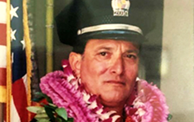 Police officer wearing several Hawaiian Leis  