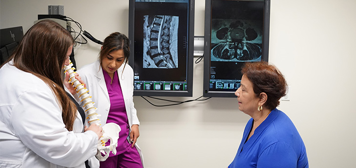 Advance Practice providers meeting with a patient at spine clinic