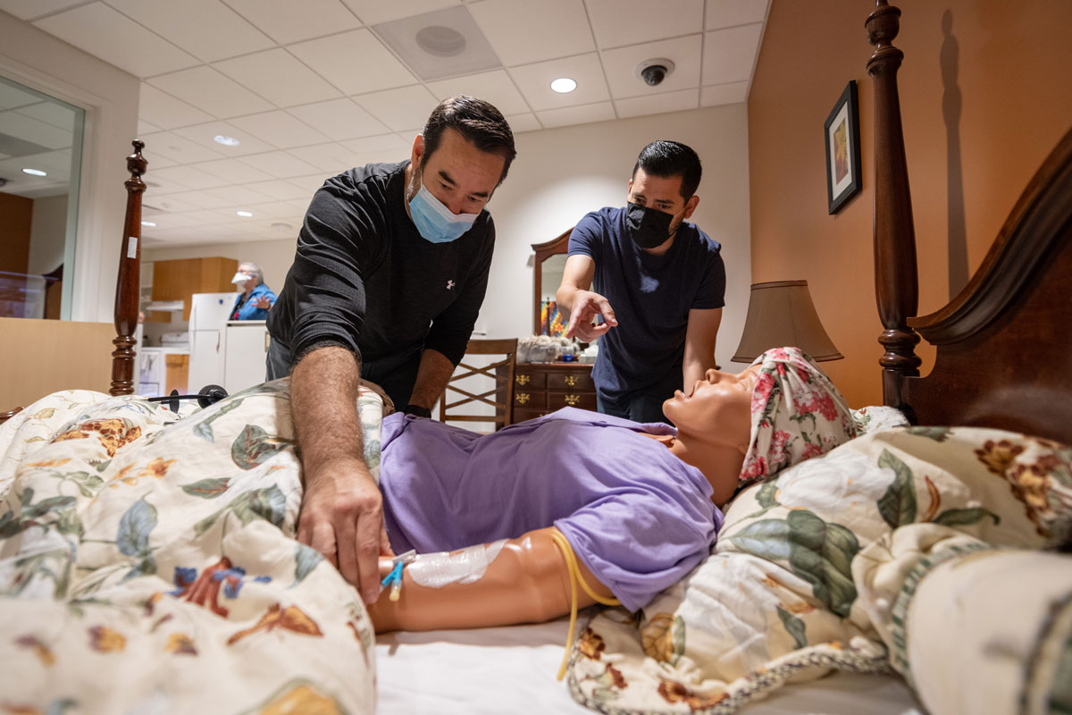 School of Nursing staff members prepare a high-fidelity manikin for a simulation exercise