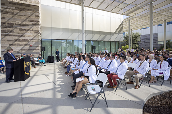 Students from the Class of 2023 Physicians Assistant program take their oath in front of Betty Irene Moore Hall.