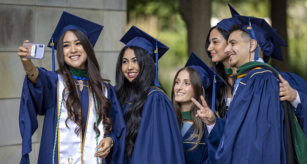 Graduating class of 2023 students gather outside of the Mondavi Center for a photo opportunity following their commencement ceremony.