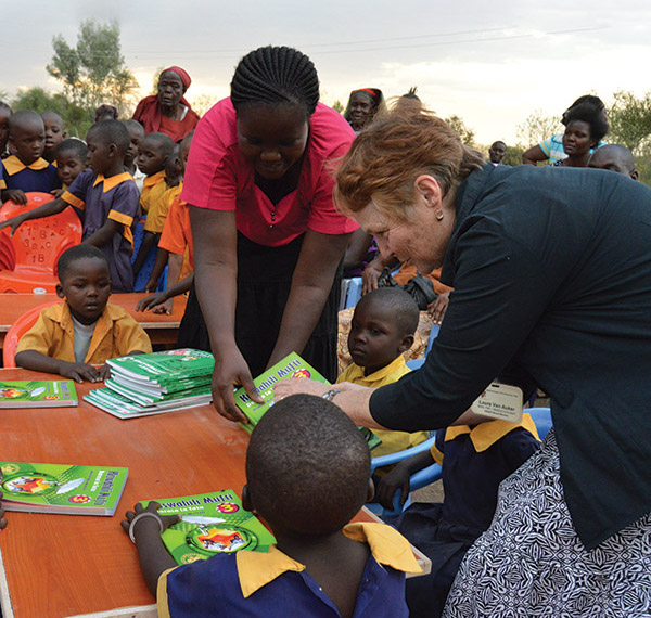 Laura Van Auker helping distribute books to Kenyan schoolchildren