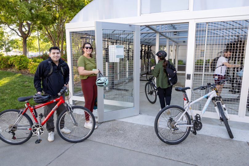 students locking bikes inside a bike shelter