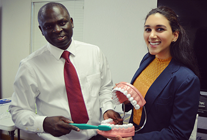 man and woman smile holding dental model of teeth