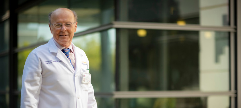 Dr. Fred Meyers stands by Education Building 