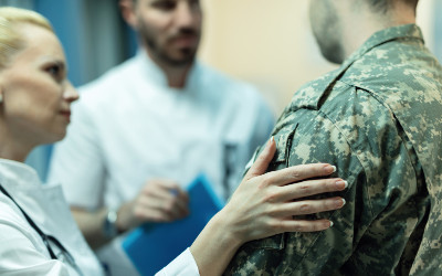Doctor with hand on arm of military veteran