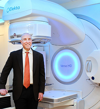 Richard Valicenti, chair of the Department of Radiation Oncology, stands in front of Versa Blue, the latest advancement in HD linear accelerators. 