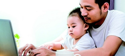 father and baby child looking at laptop together
