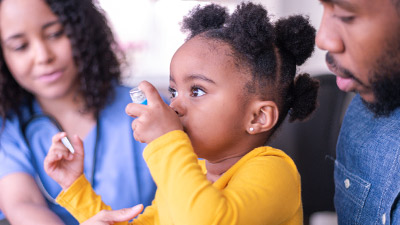 stock image of young female pediatric patient using an inhaler