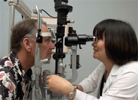 PHOTO — Ophthalmologist Susanna Park examines Michael Bone's eye five weeks after his final proton-beam treatment.