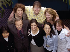 PHOTO — Dina Howard, surrounded by seven members of her treatment team. Clockwise, from first-row left: Radiation oncologist Janice Ryu, social worker Carolyn Guadagnolo, oncology nurses Mia Wilson and Teri Lown, radiation therapist Marianne Kern, oncology pharmacist Amy Tam, and surgical oncologist James Goodnight.