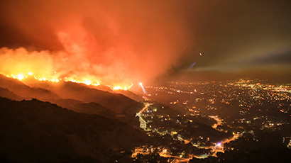 Distant view of hills on fire near a city